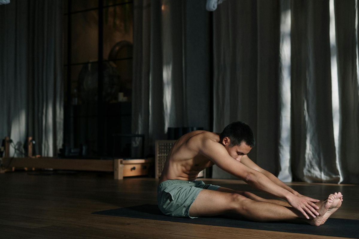 Person practicing yoga in a dark room with focused lighting